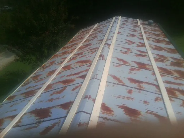 Rusted metal roof panels with new wood purlins before replacement — Storm Damage Roof Repair in Peosta by Roofing Brothers