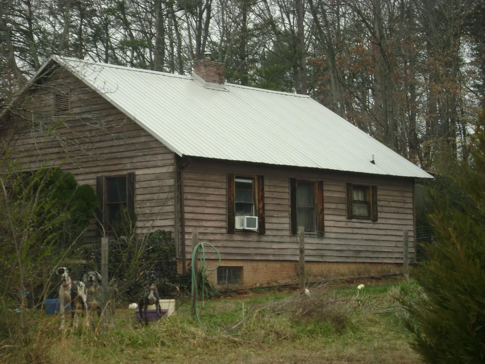 White metal roof on an old wood sided farmhouse, from a Metal Roof Installation job in Peosta